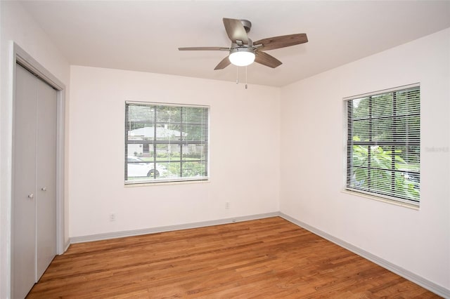 unfurnished bedroom with ceiling fan, a closet, and hardwood / wood-style floors