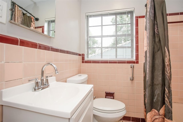 bathroom with tile walls, toilet, and vanity