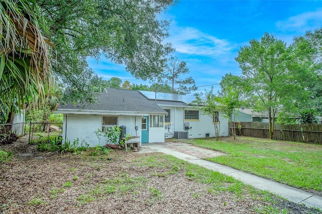 back of property with cooling unit and a lawn