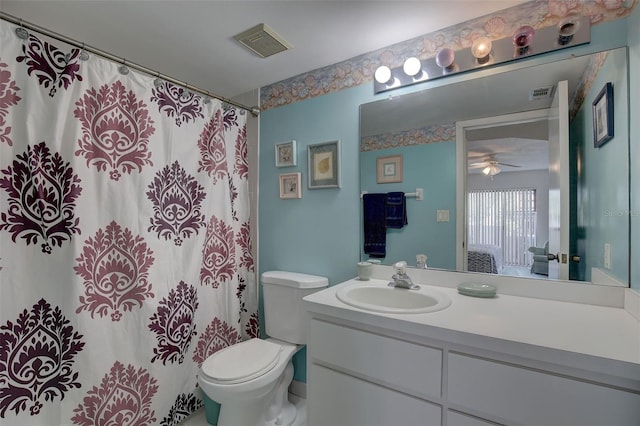 bathroom with ceiling fan, toilet, and large vanity