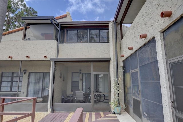 rear view of property featuring a wooden deck