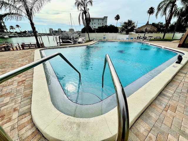 view of swimming pool featuring a water view and a patio