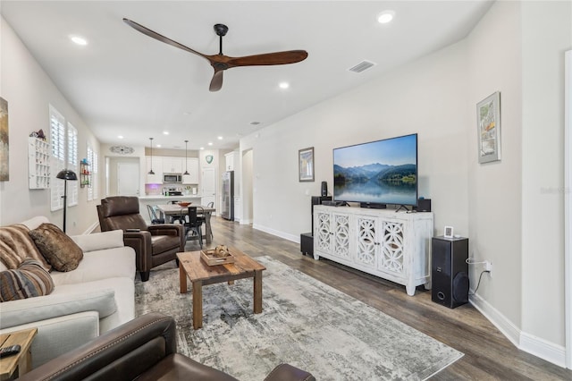 living room with dark hardwood / wood-style flooring and ceiling fan