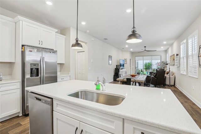 kitchen featuring stainless steel appliances, ceiling fan, sink, white cabinets, and hanging light fixtures