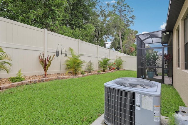 view of yard featuring glass enclosure and central AC unit