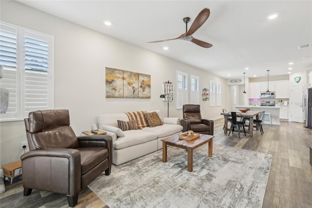 living room featuring recessed lighting, ceiling fan, and wood finished floors