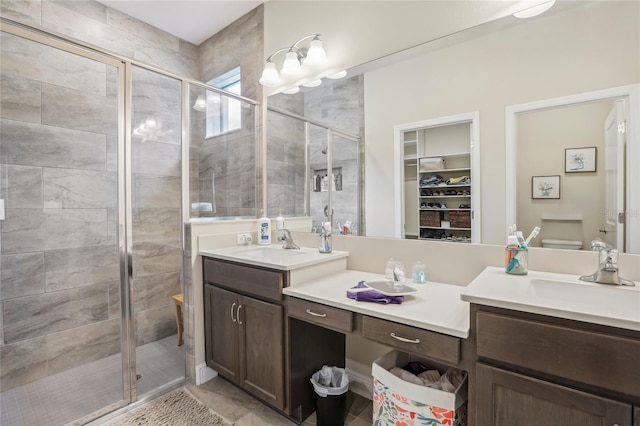 full bathroom featuring a stall shower, a spacious closet, and vanity