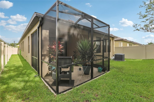 exterior space with cooling unit, a lanai, a fenced backyard, and a yard