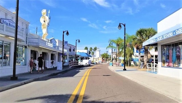 view of road featuring street lights, curbs, and sidewalks