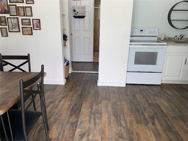 kitchen featuring white range with electric cooktop, dark hardwood / wood-style floors, white cabinets, and sink