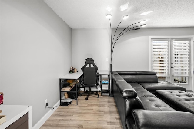 living room with a textured ceiling and light hardwood / wood-style flooring