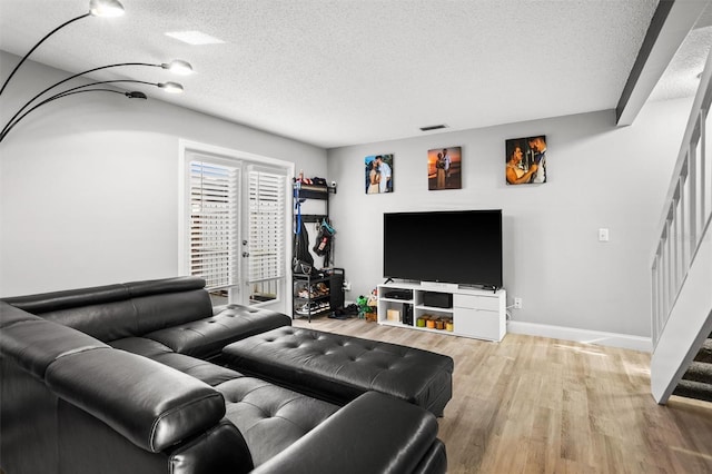 living room featuring wood-type flooring and a textured ceiling