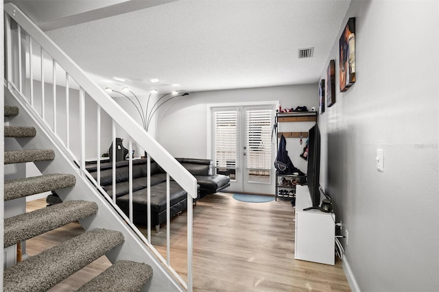 stairway featuring wood-type flooring and a textured ceiling