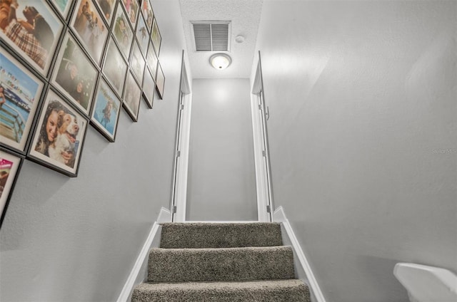 staircase with a textured ceiling