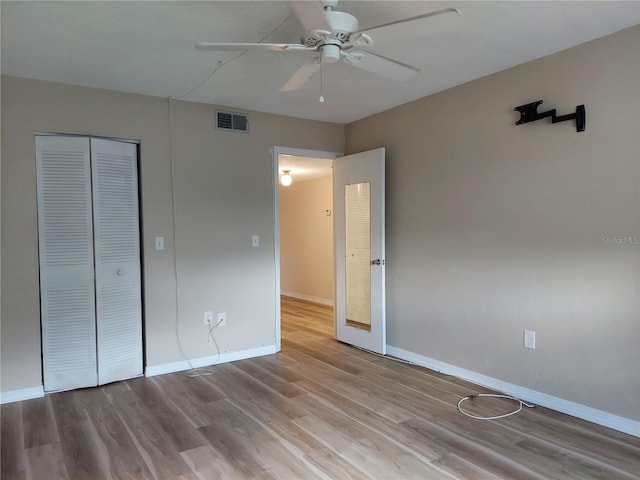 unfurnished bedroom with ceiling fan, a closet, and light hardwood / wood-style floors