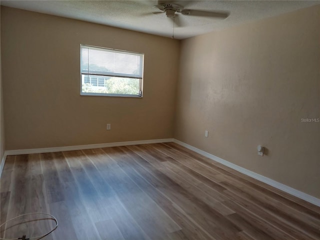 unfurnished room featuring ceiling fan, hardwood / wood-style floors, and a textured ceiling