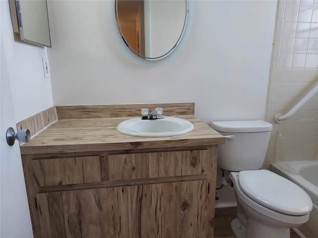 bathroom with vanity, toilet, and a tub