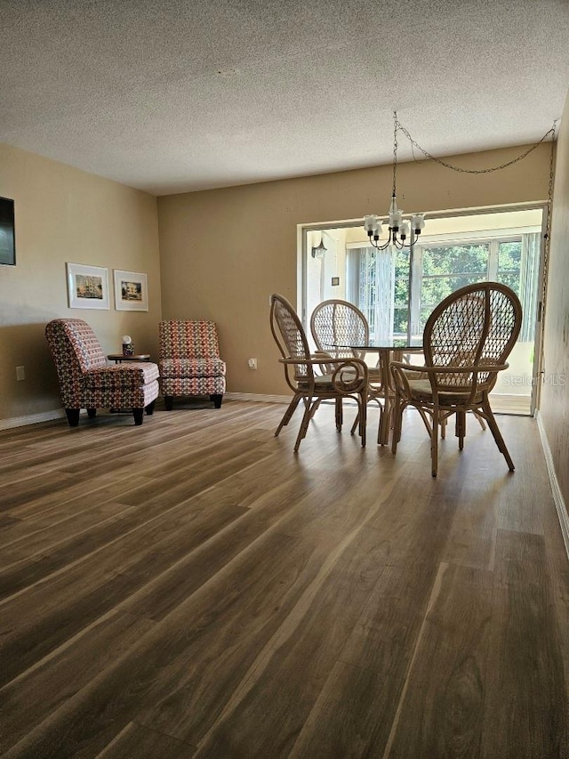 dining room with hardwood / wood-style floors, a textured ceiling, and a notable chandelier