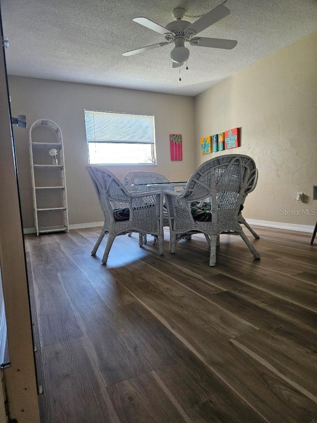 dining area with a textured ceiling, ceiling fan, and dark hardwood / wood-style floors