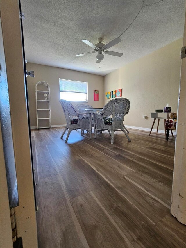 interior space featuring dark hardwood / wood-style floors, ceiling fan, and a textured ceiling