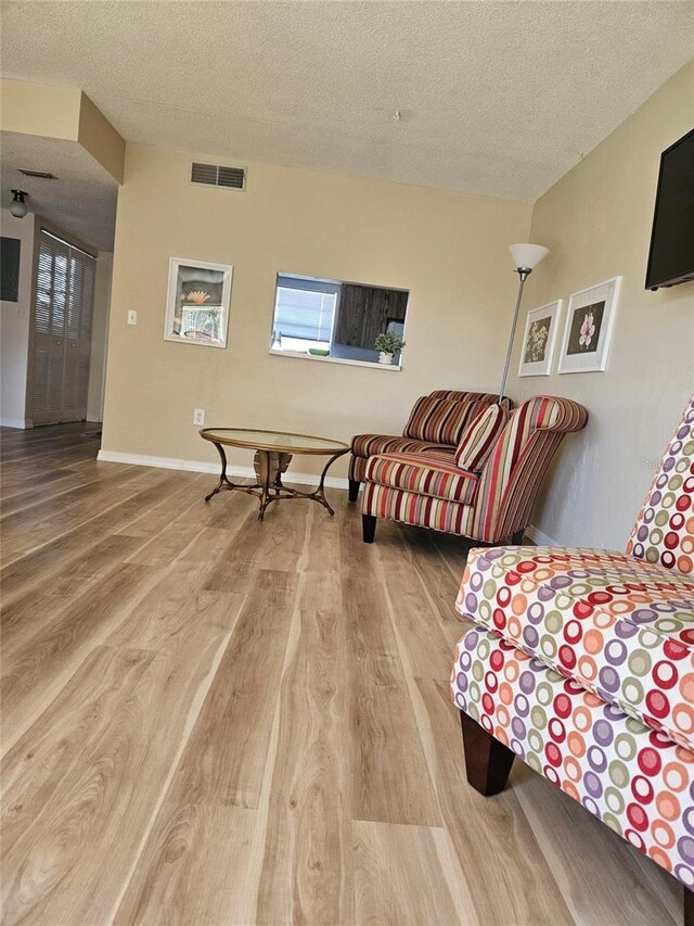 living room featuring a textured ceiling and hardwood / wood-style flooring