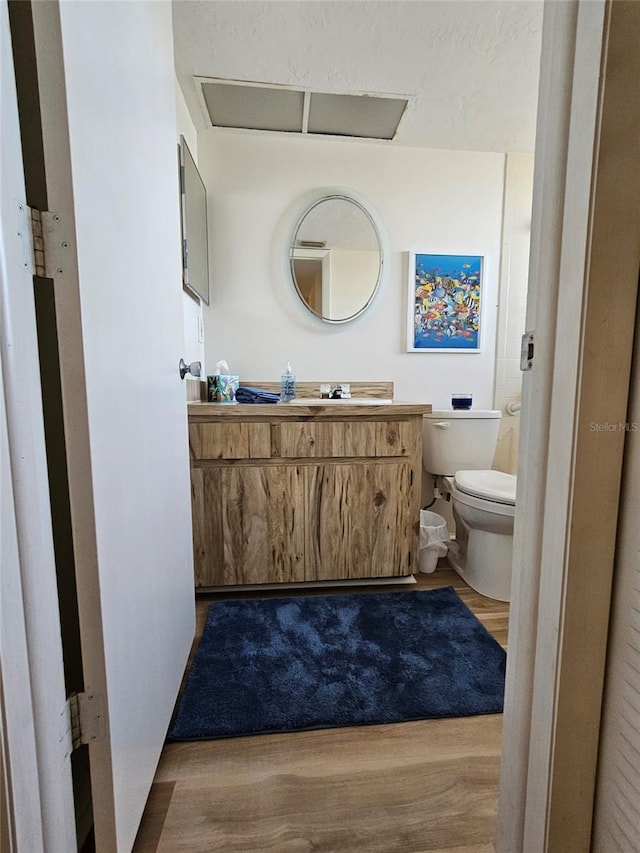 bathroom with vanity, hardwood / wood-style flooring, and toilet