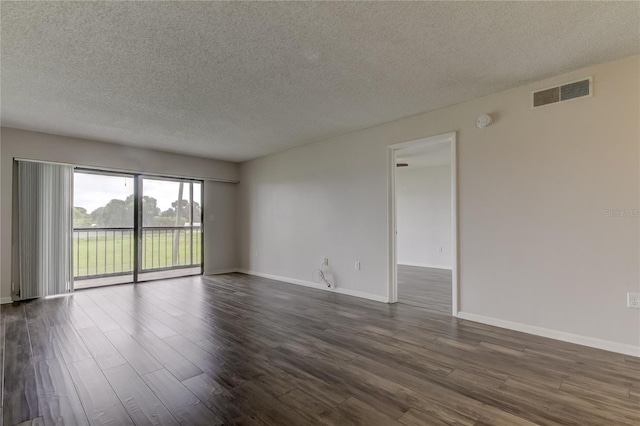 unfurnished room featuring dark hardwood / wood-style flooring and a textured ceiling