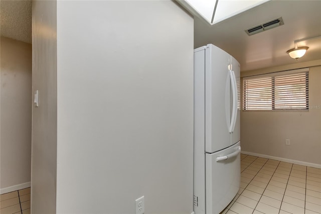 kitchen featuring white fridge and light tile patterned flooring