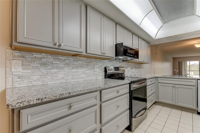 kitchen with stainless steel range with electric stovetop, sink, tasteful backsplash, light tile patterned flooring, and light stone counters