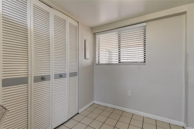 unfurnished bedroom with light tile patterned floors and a closet