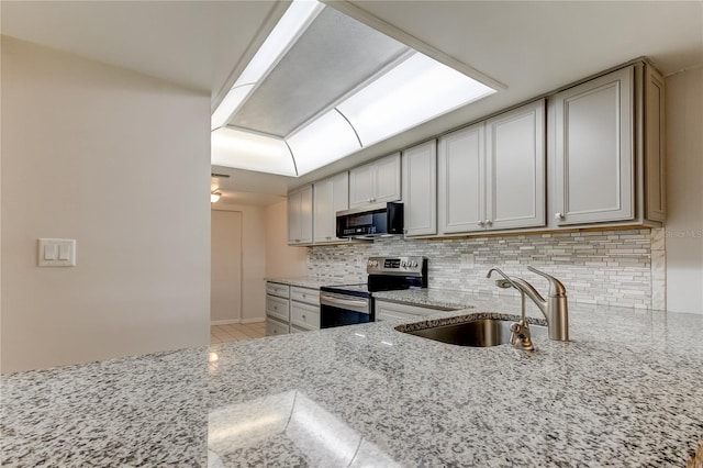 kitchen with backsplash, light stone counters, electric stove, and sink