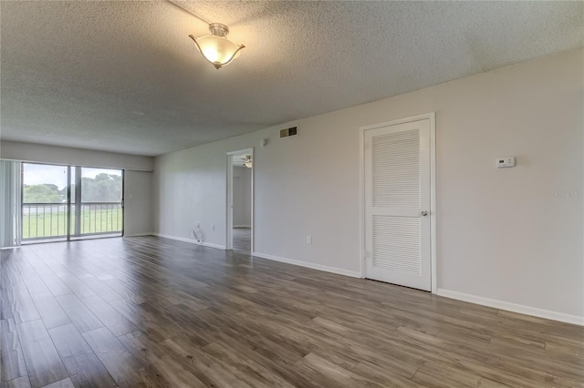 unfurnished room with hardwood / wood-style floors and a textured ceiling