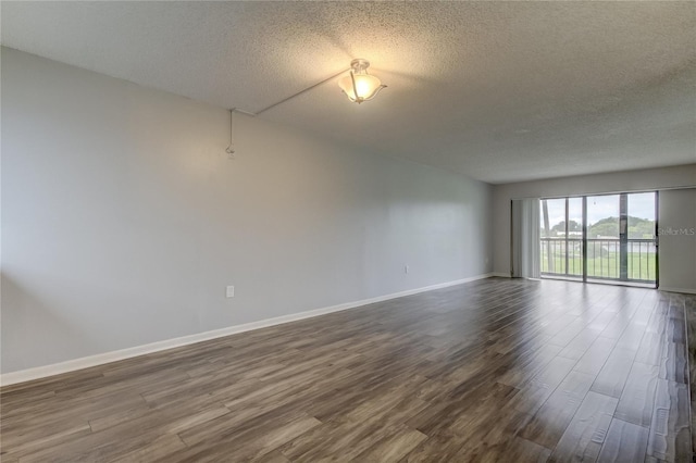 unfurnished room with a textured ceiling and dark hardwood / wood-style floors