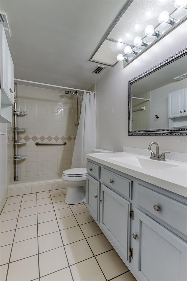 bathroom featuring tile patterned floors, curtained shower, vanity, and toilet