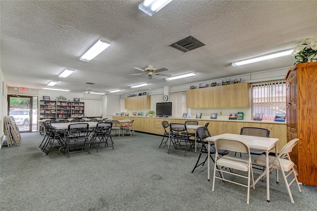 dining space featuring carpet flooring, a textured ceiling, ceiling fan, and a healthy amount of sunlight