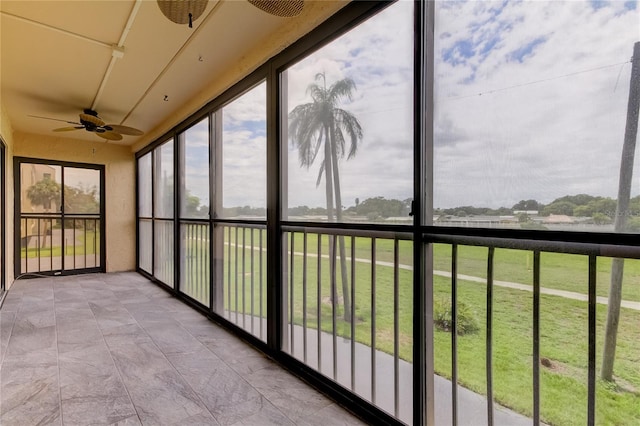 unfurnished sunroom featuring ceiling fan