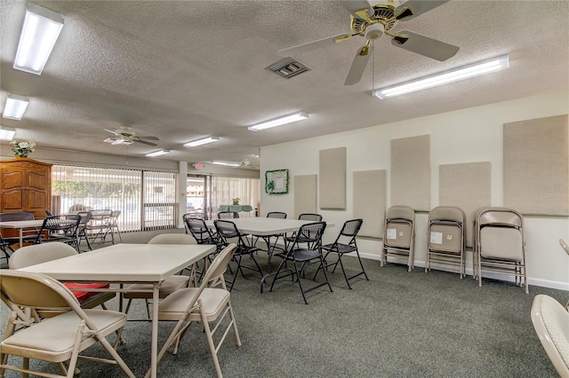 dining room featuring ceiling fan, a textured ceiling, and dark colored carpet