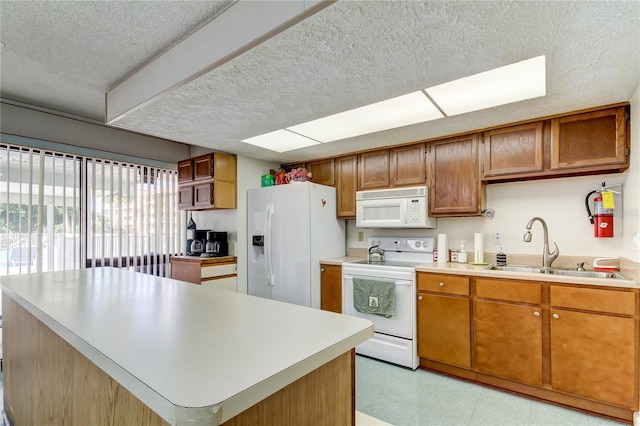 kitchen with a center island, white appliances, and sink