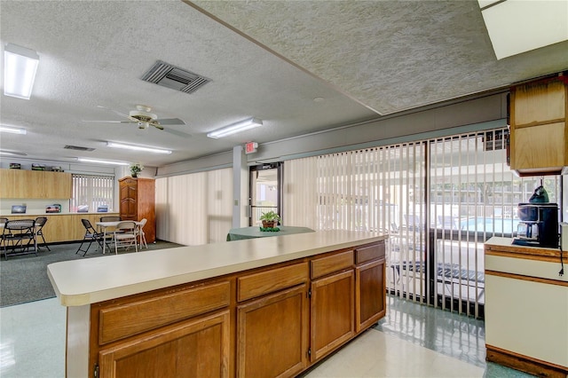 kitchen with a textured ceiling and ceiling fan