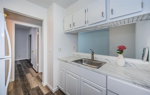 kitchen with dark hardwood / wood-style flooring, sink, white cabinets, and white fridge