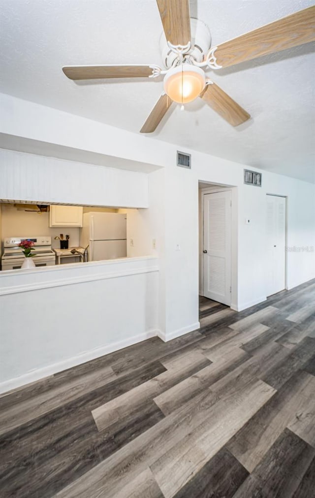 unfurnished living room with ceiling fan and dark hardwood / wood-style floors