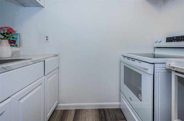 kitchen featuring dark hardwood / wood-style floors, white electric range oven, and white cabinets