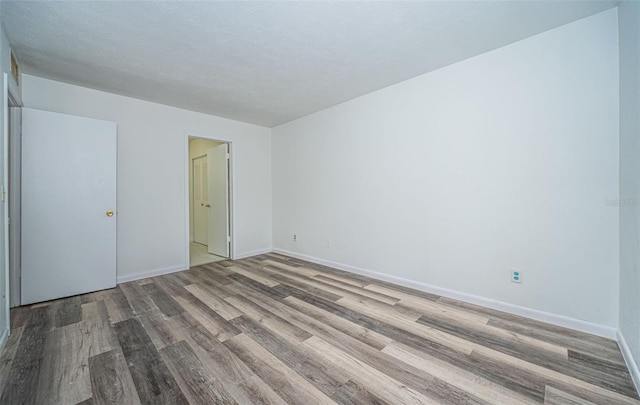 unfurnished bedroom featuring a textured ceiling and hardwood / wood-style flooring