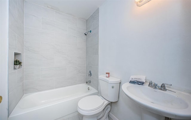 full bathroom featuring toilet, tiled shower / bath combo, and sink