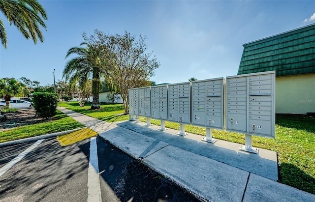 surrounding community with mail boxes and a lawn