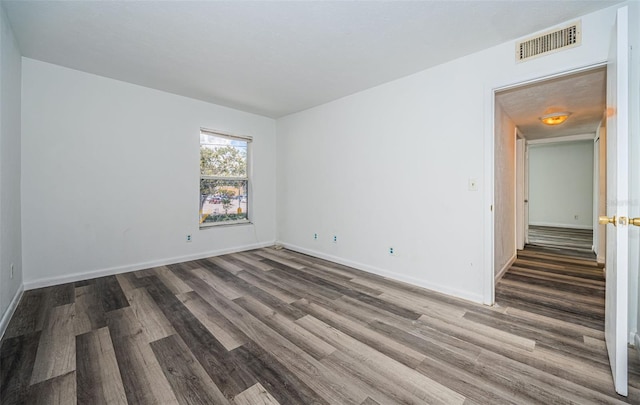 spare room with dark hardwood / wood-style flooring