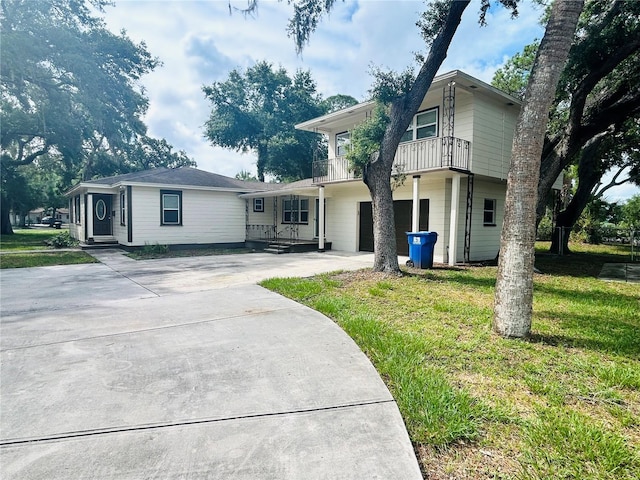 view of front of house with a balcony and a front lawn