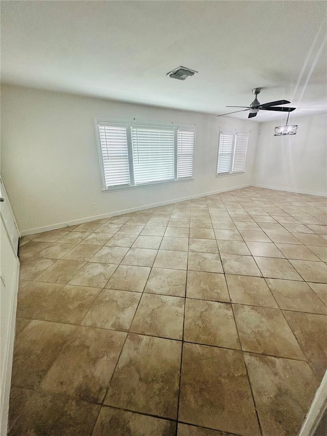 tiled spare room featuring ceiling fan