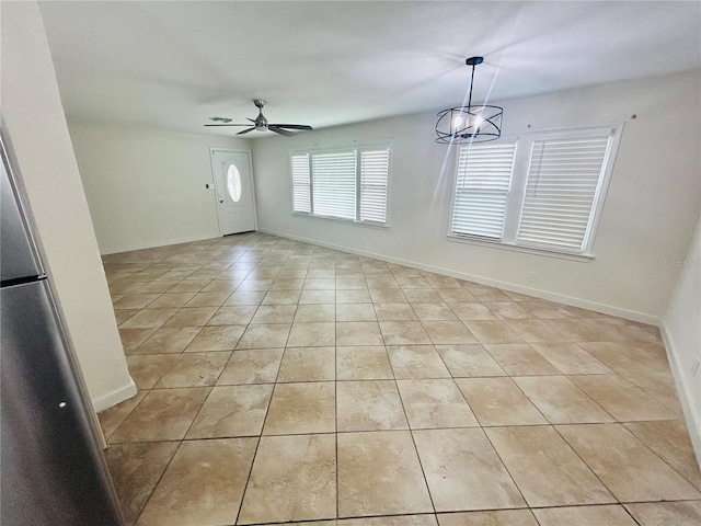 interior space featuring ceiling fan with notable chandelier