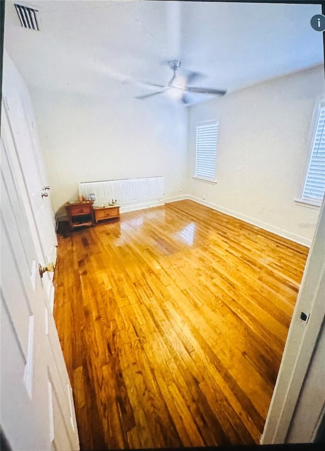 spare room with hardwood / wood-style floors and ceiling fan